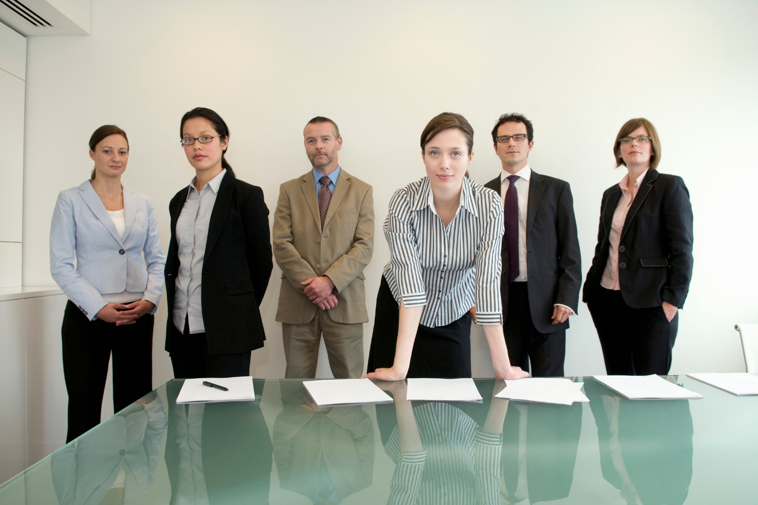 Groupe de professionnels en tenue formelle réunis autour d'une table lors d'une convocation devant un comité de discipline