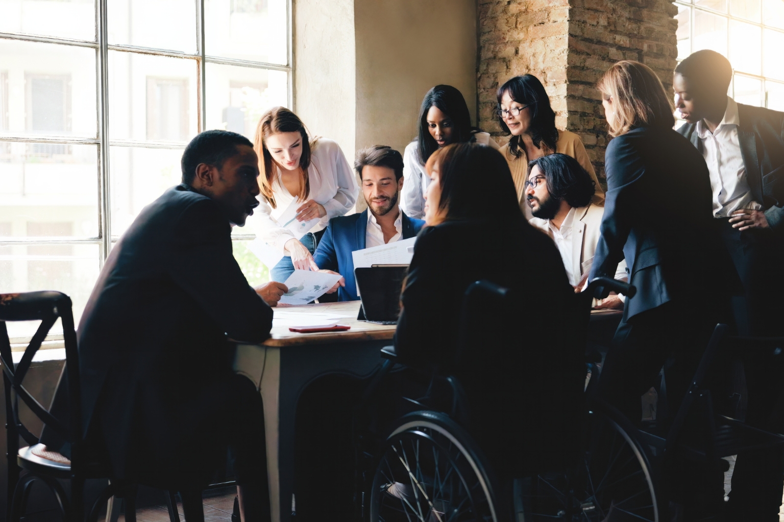 Candidats réunis autour d’une table lors d’un processus de recrutement, illustrant la discrimination à l’embauche.