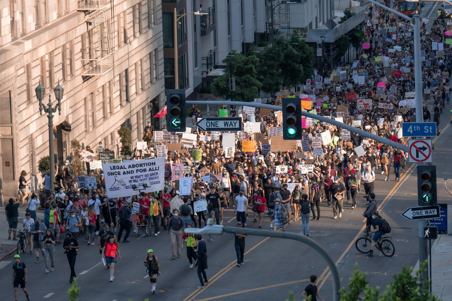 Manifestation de rue avec une foule portant des pancartes, illustrant le débat social entourant le droit à l’avortement.